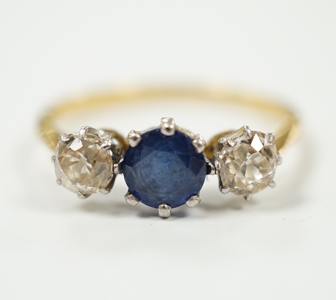 A yellow metal, single stone sapphire and two stone diamond set ring, size N/O, gross weight 2.2 grams.